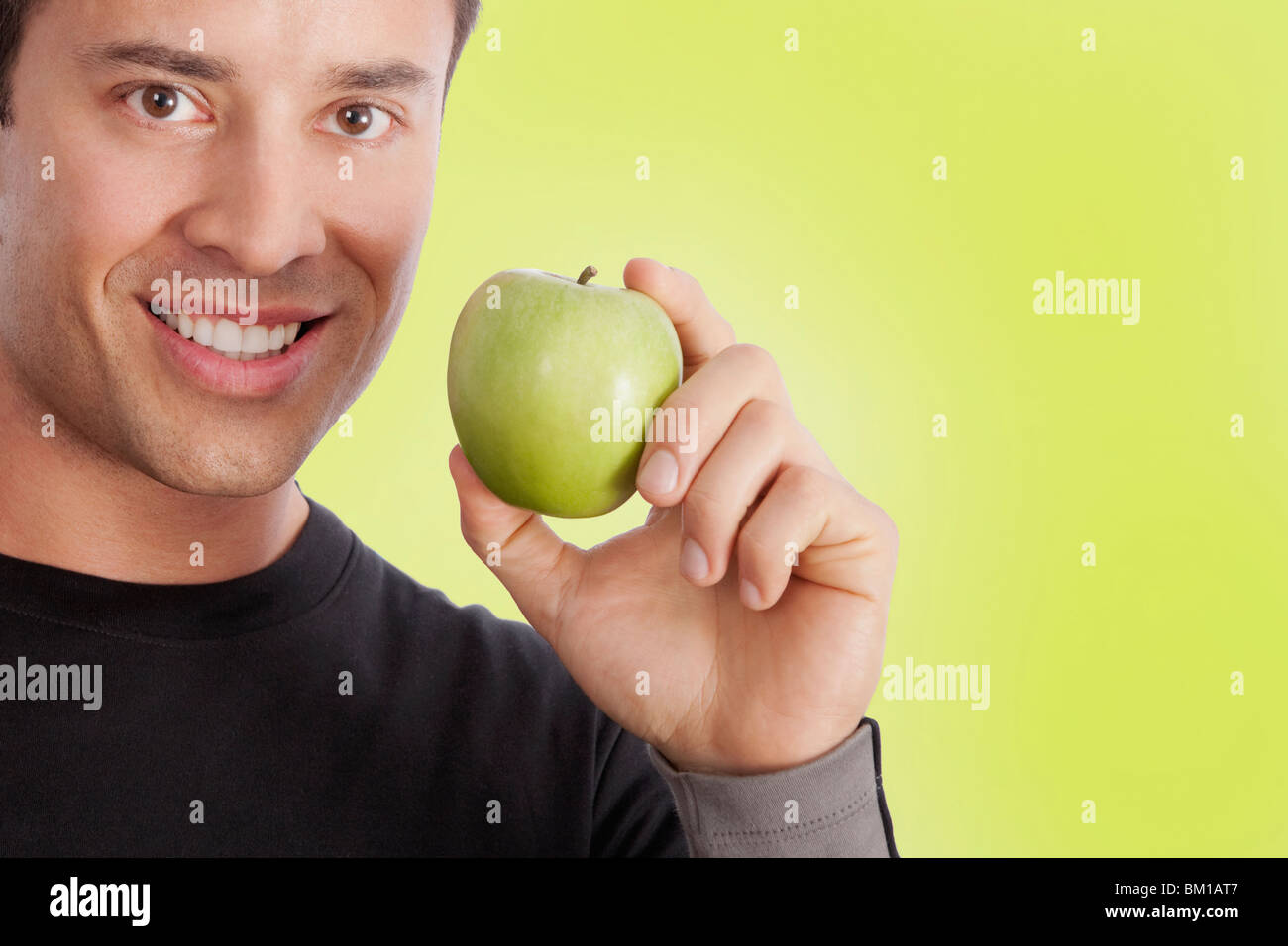 Man holding a green apple Stock Photo - Alamy