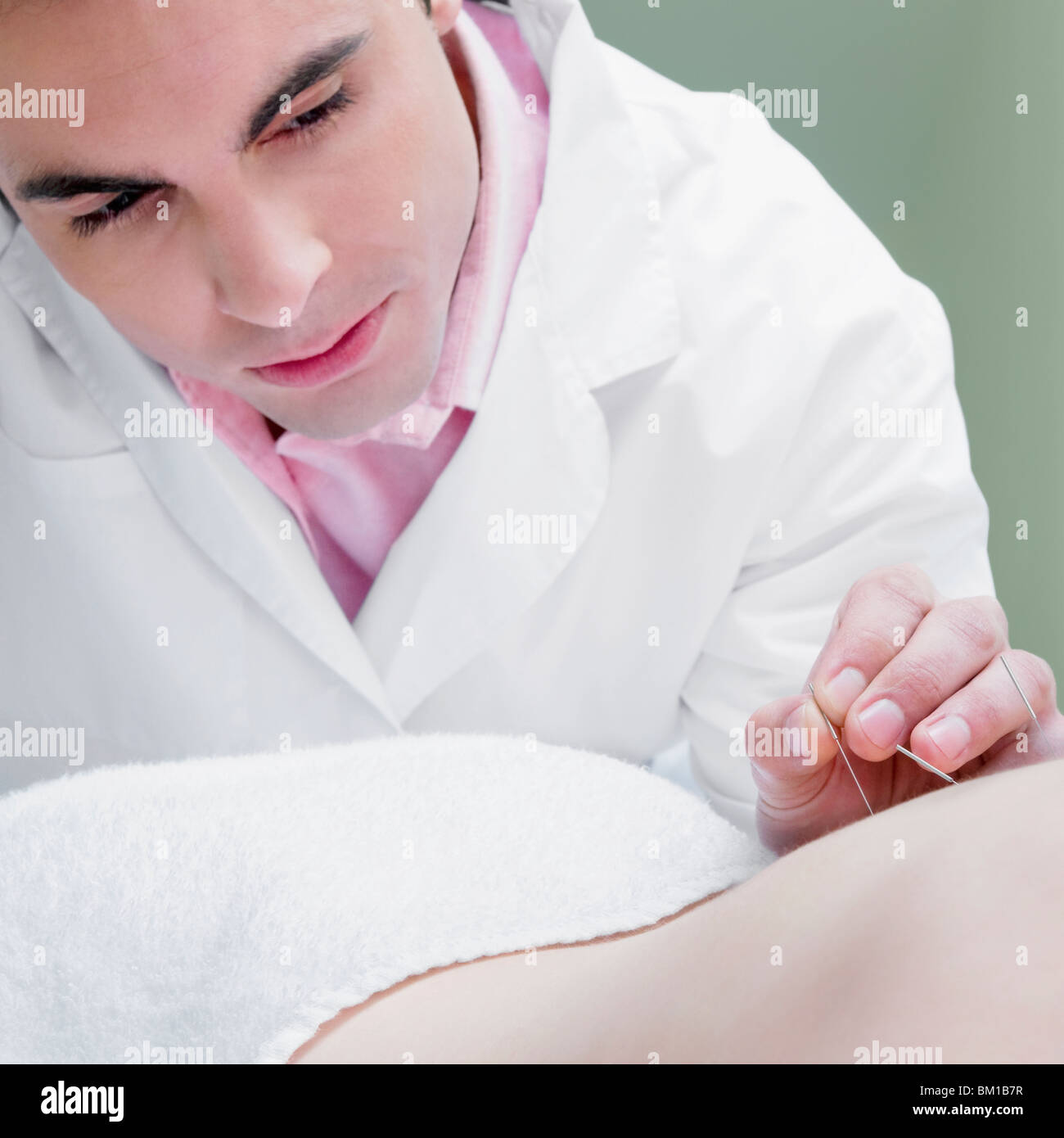 Acupuncturist applying needles on a person's back Stock Photo Alamy