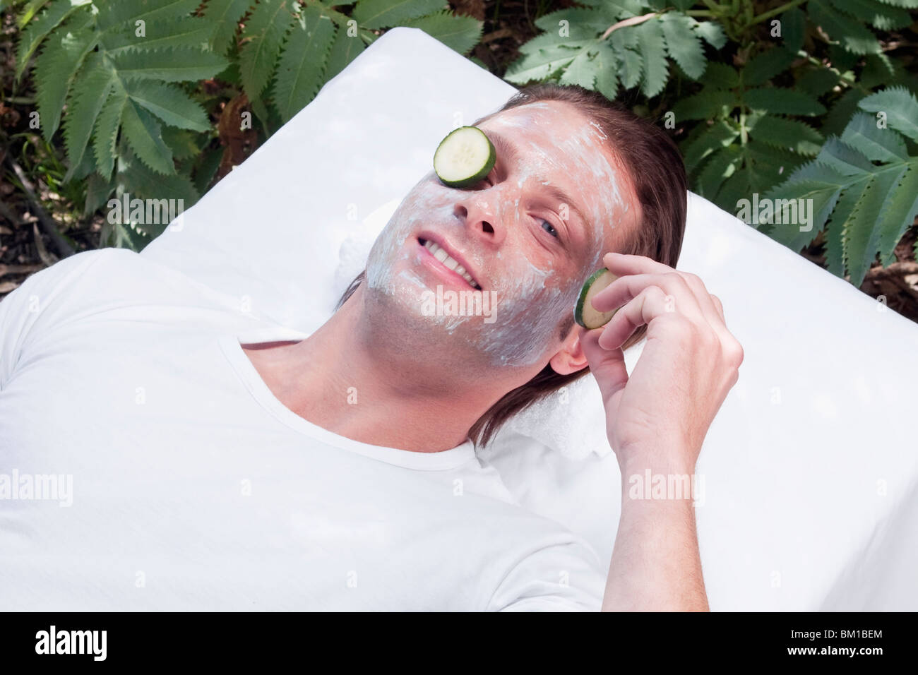 Cucumber slice on a man's eye Stock Photo