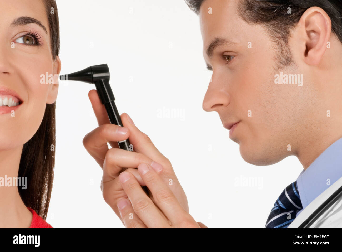 Doctor checking a woman's ear with an otoscope Stock Photo Alamy