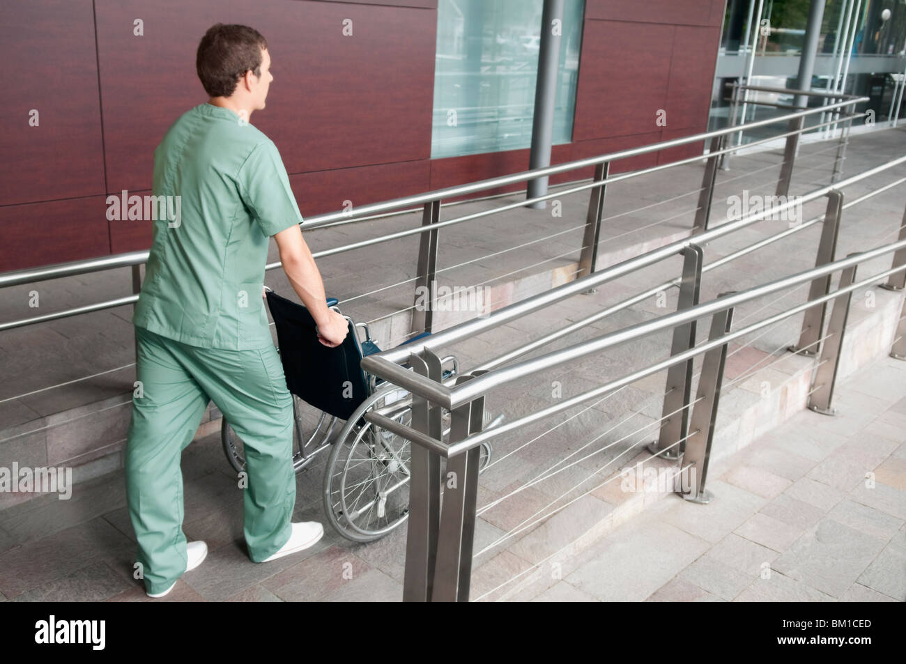 Male nurse carrying a wheelchair Stock Photo