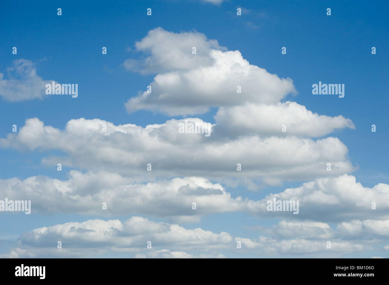 Fluffy white clouds in a bright blue sky Stock Photo - Alamy