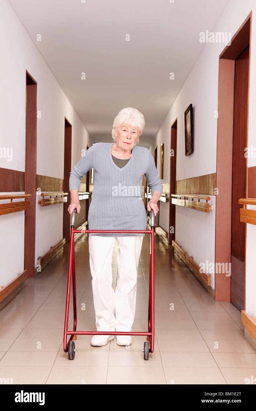 Woman walking with the help of a walker Stock Photo - Alamy