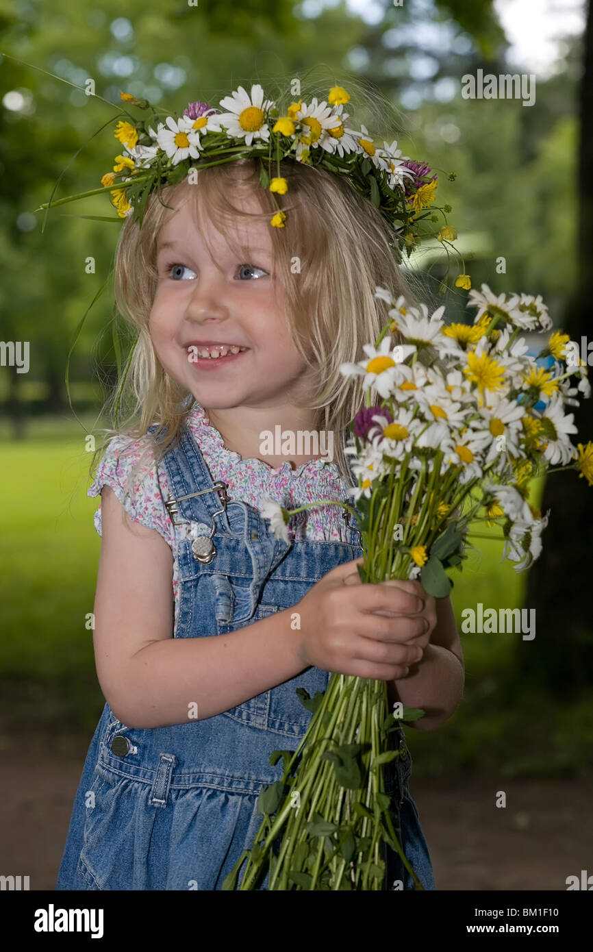 Little smiling girl with a bunch of flowers and in a wreath Stock Photo ...