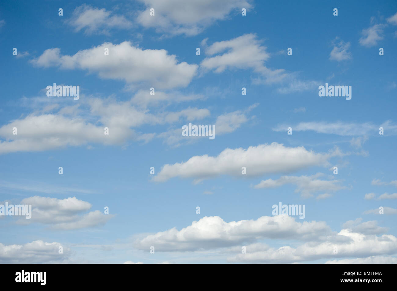 Fluffy white clouds in a bright blue sky Stock Photo - Alamy