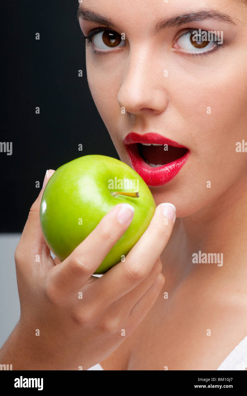 Closeup of a woman eating a granny smith apple Stock Photo Alamy
