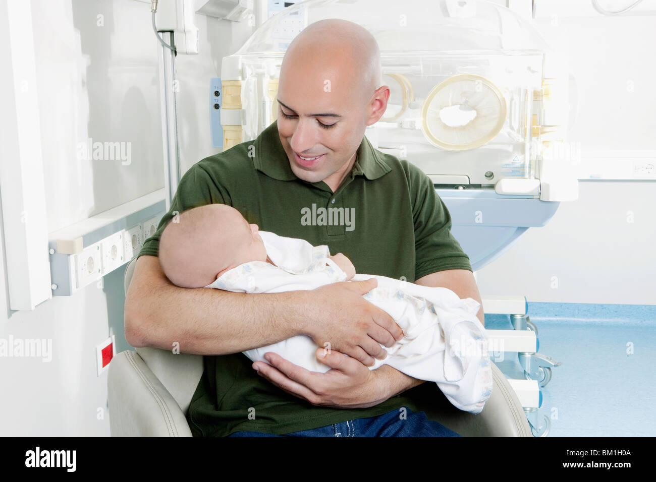 Man carrying his newborn baby Stock Photo Alamy