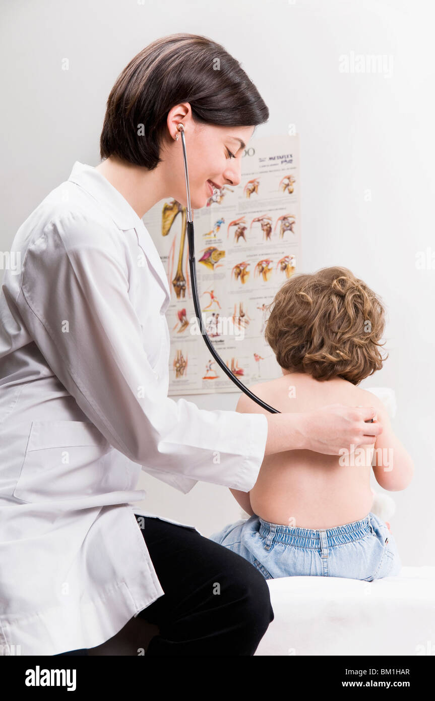 Female doctor examining a baby boy with a stethoscope Stock Photo