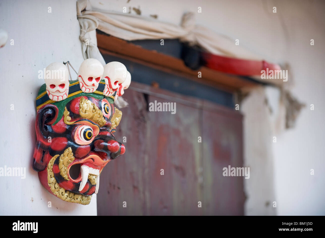 Mask and phallus hanging on a door to protect its occupants, near the temple of the Divine Madman, Metshina, Punakha, Bhutan Stock Photo
