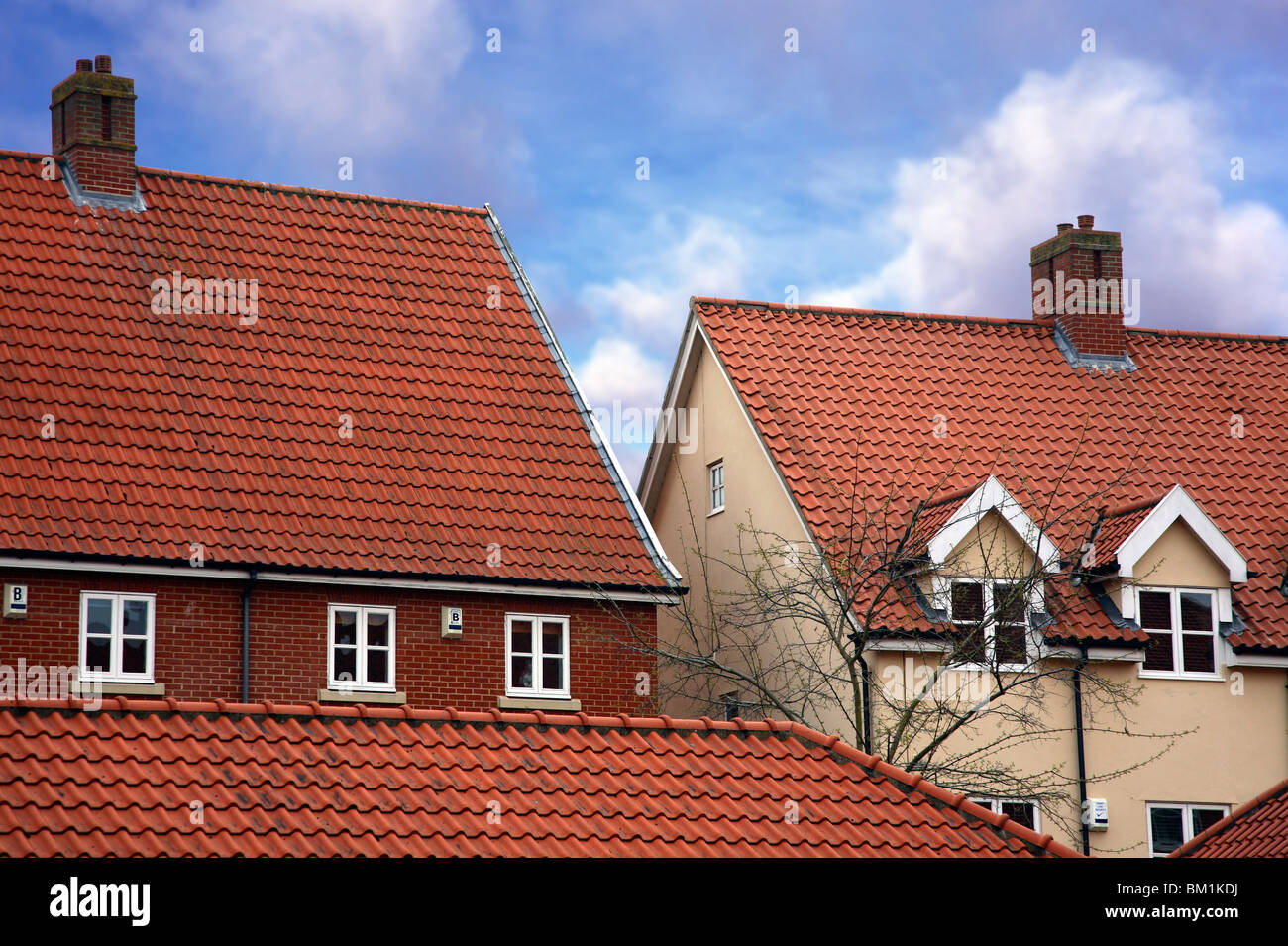 New build houses against a blue sky with clouds Stock Photo - Alamy