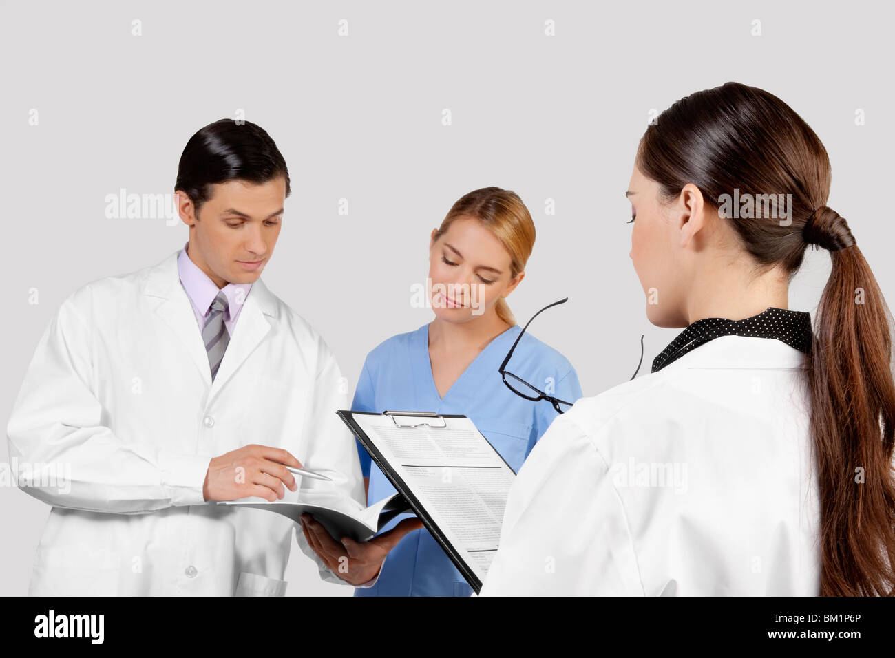 Doctors and a nurse discussing about medical record Stock Photo