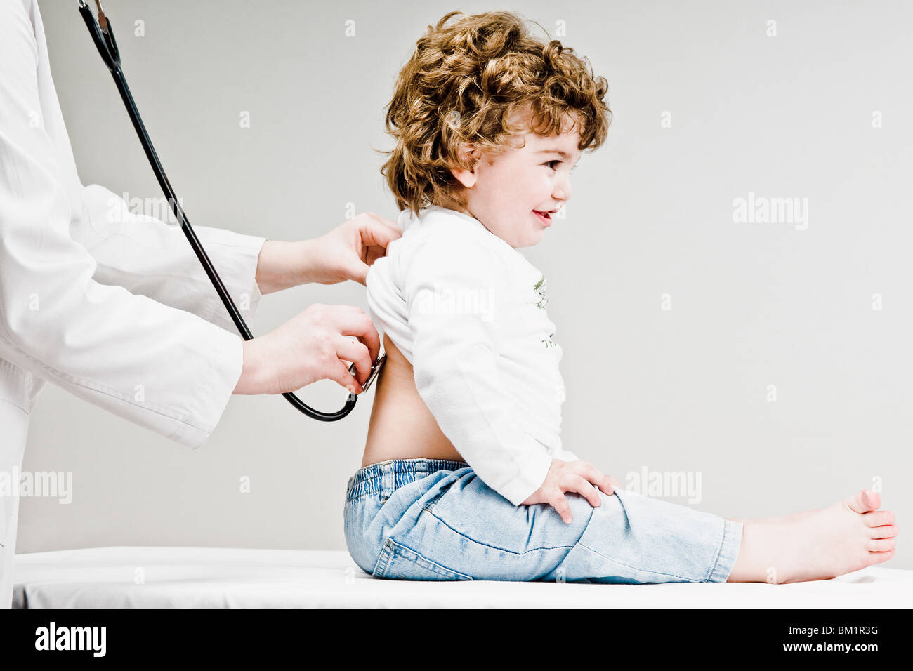 Female doctor examining a baby boy with a stethoscope Stock Photo