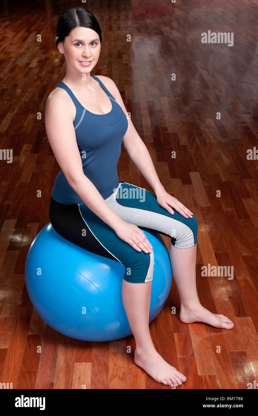 Woman sitting on a fitness ball in a gym Stock Photo - Alamy