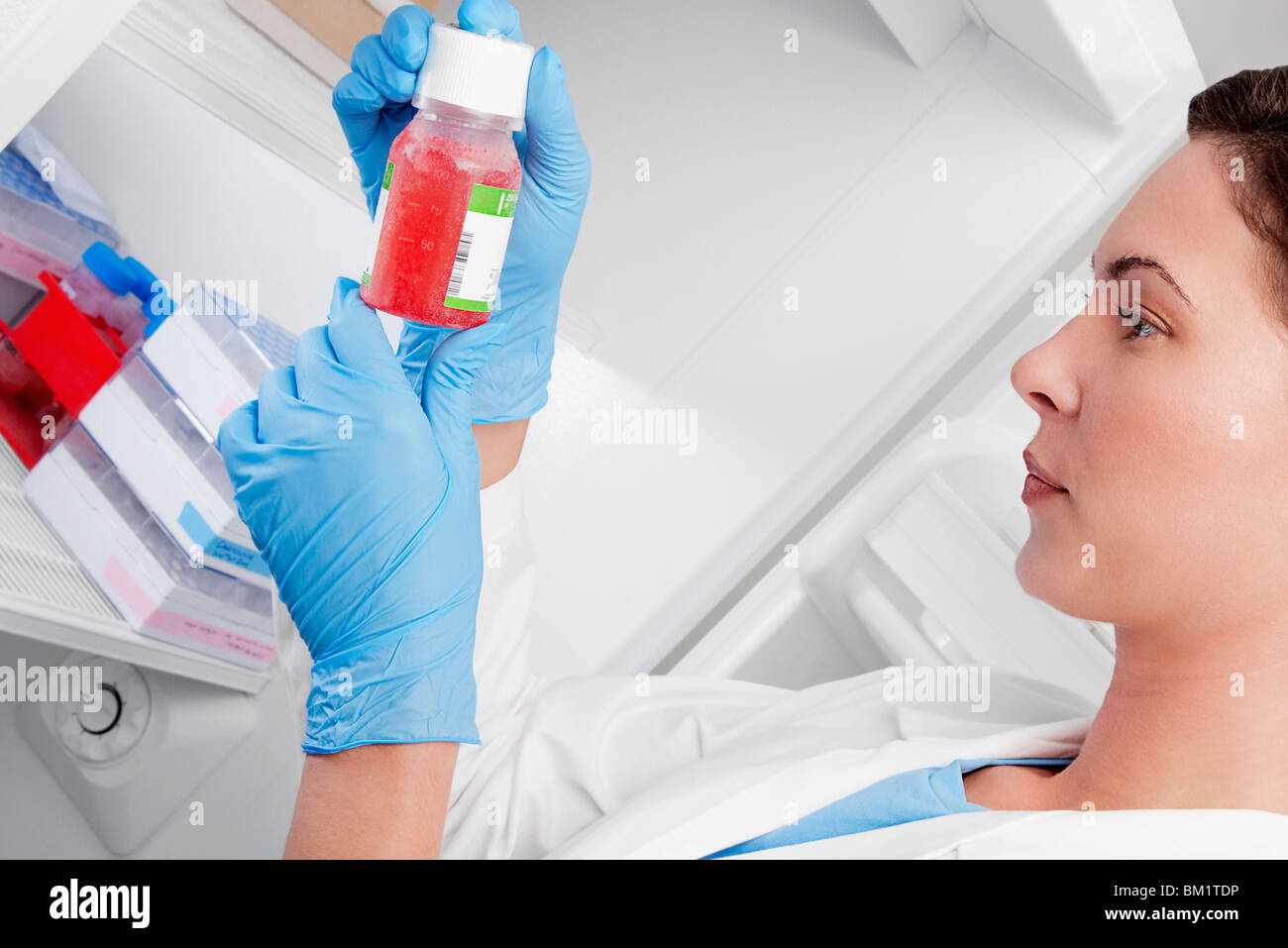 Female doctor holding a bottle of solution in a laboratory Stock Photo