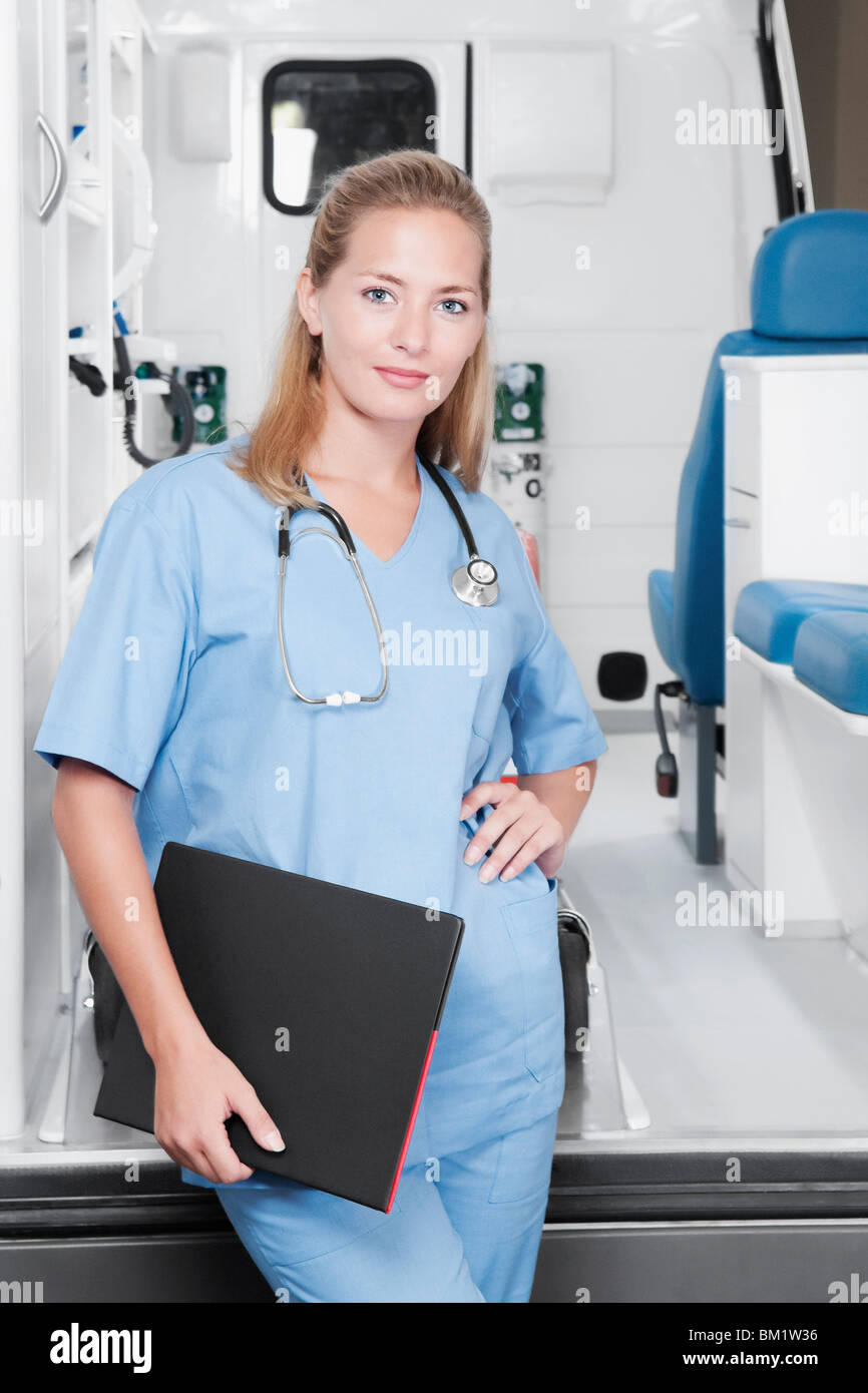 Female nurse standing in front of an ambulance Stock Photo