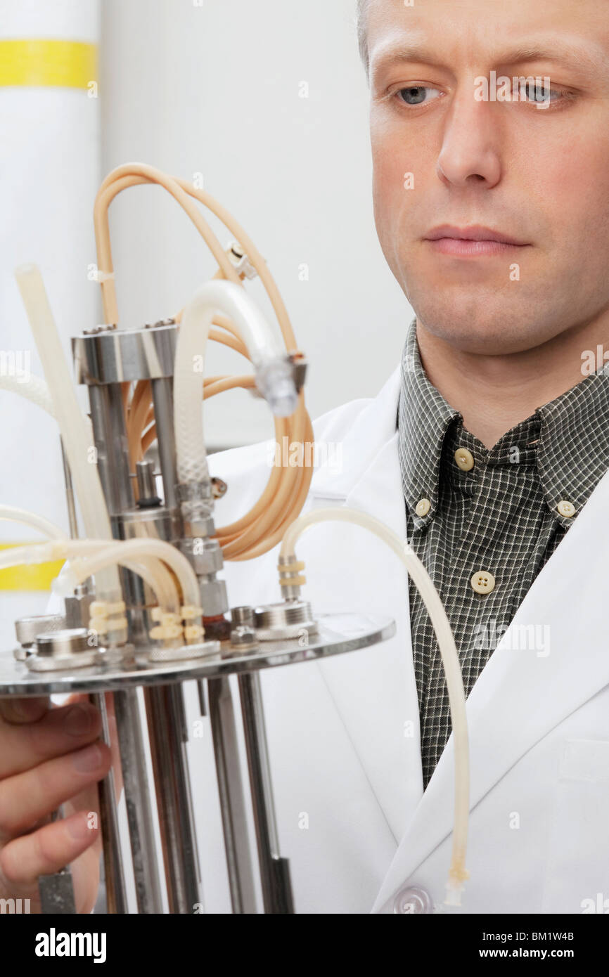 Scientist working on a bioreactor headplate with mixer assembly and methanol sensor probe Stock Photo