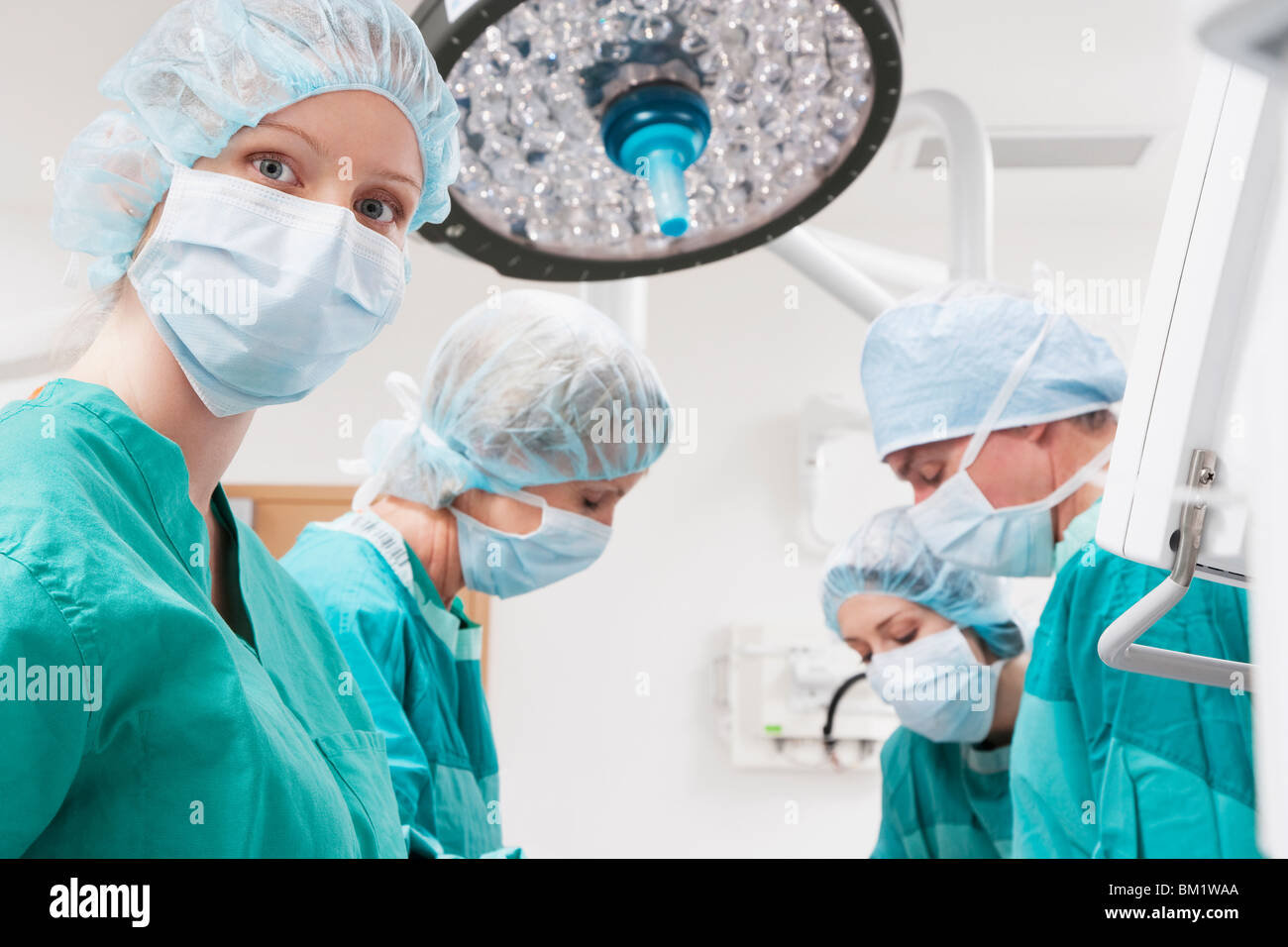 Surgeons performing a surgery in an operating room Stock Photo