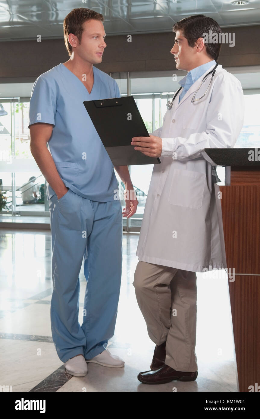 Doctor discussing with a male nurse discussing Stock Photo