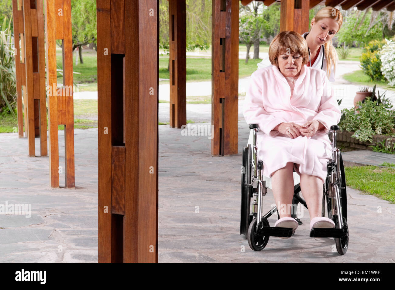 Doctor pushing a patient sitting in a wheelchair Stock Photo