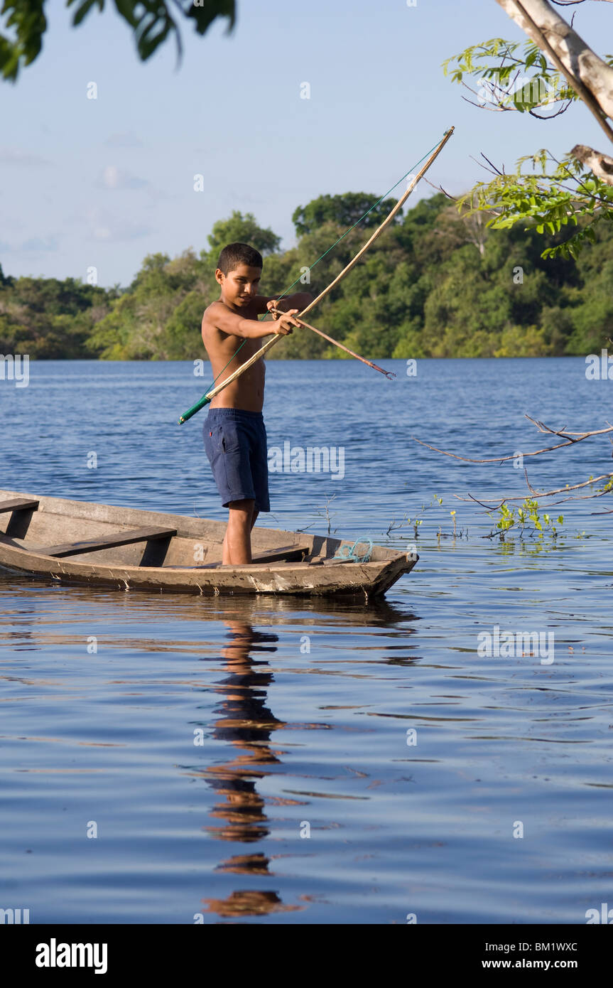 Boy fishing in a lake with a bow and arrow, Lago Miwa, as