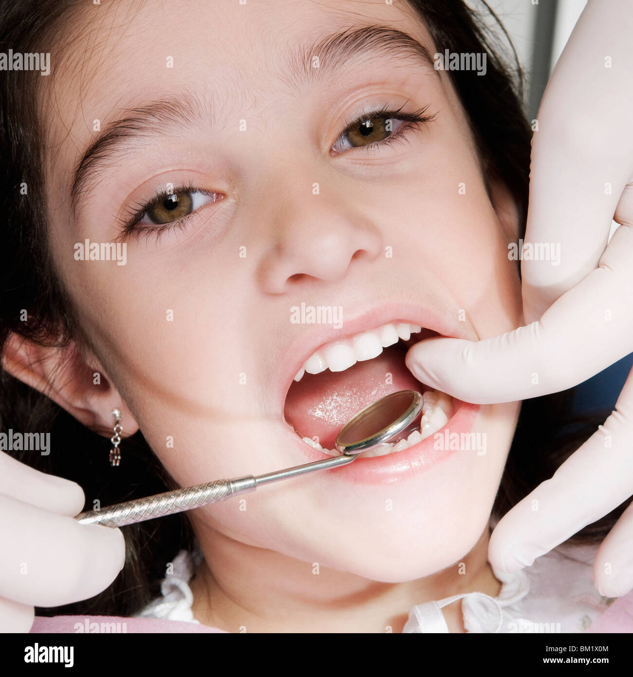 Dentist checking girl's teeth Stock Photo