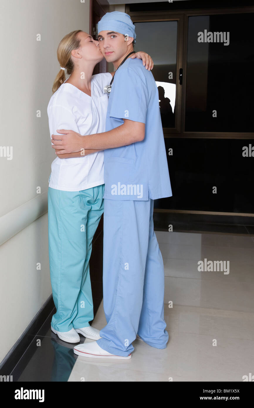 Male and a female nurse romancing in a hospital corridor Stock Photo