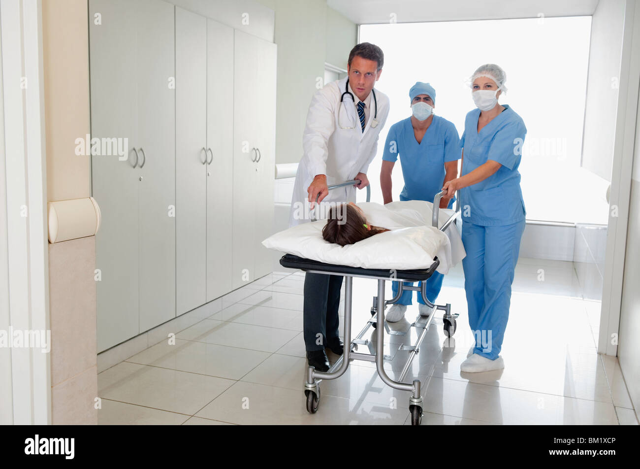 Doctors pushing a patient on a hospital Gurney in a hospital corridor