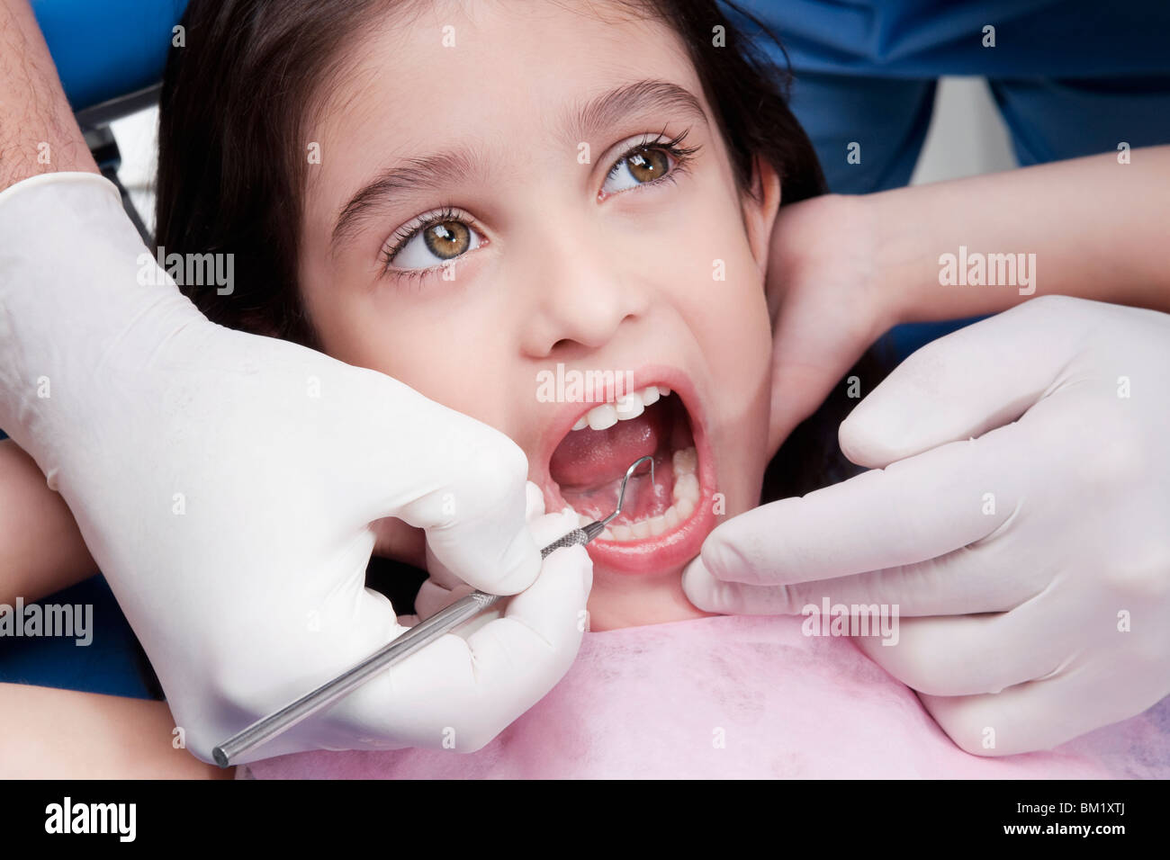 Dentist examining a girl's teeth Stock Photo