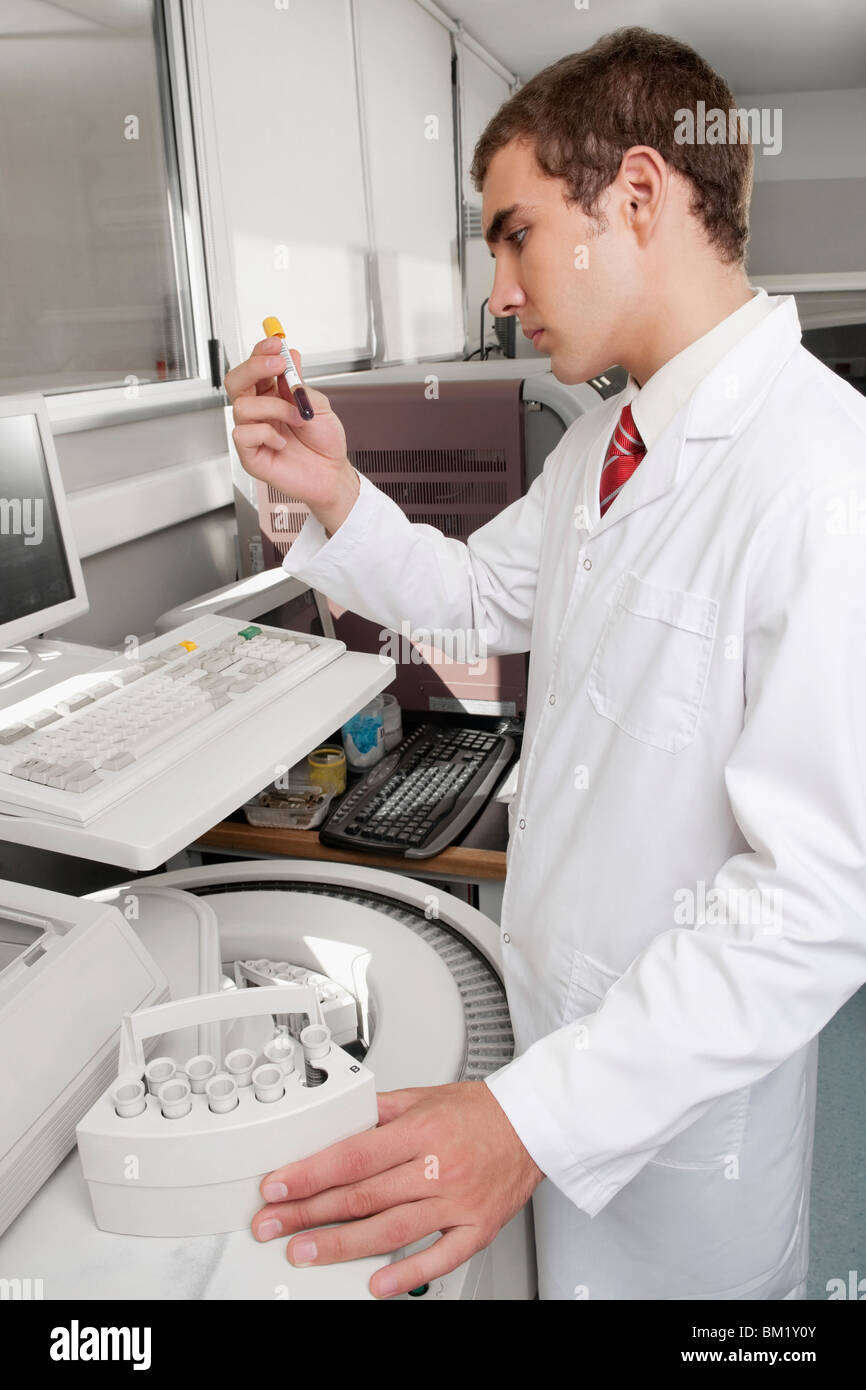 Lab technician analyzing a blood sample in a test tube Stock Photo