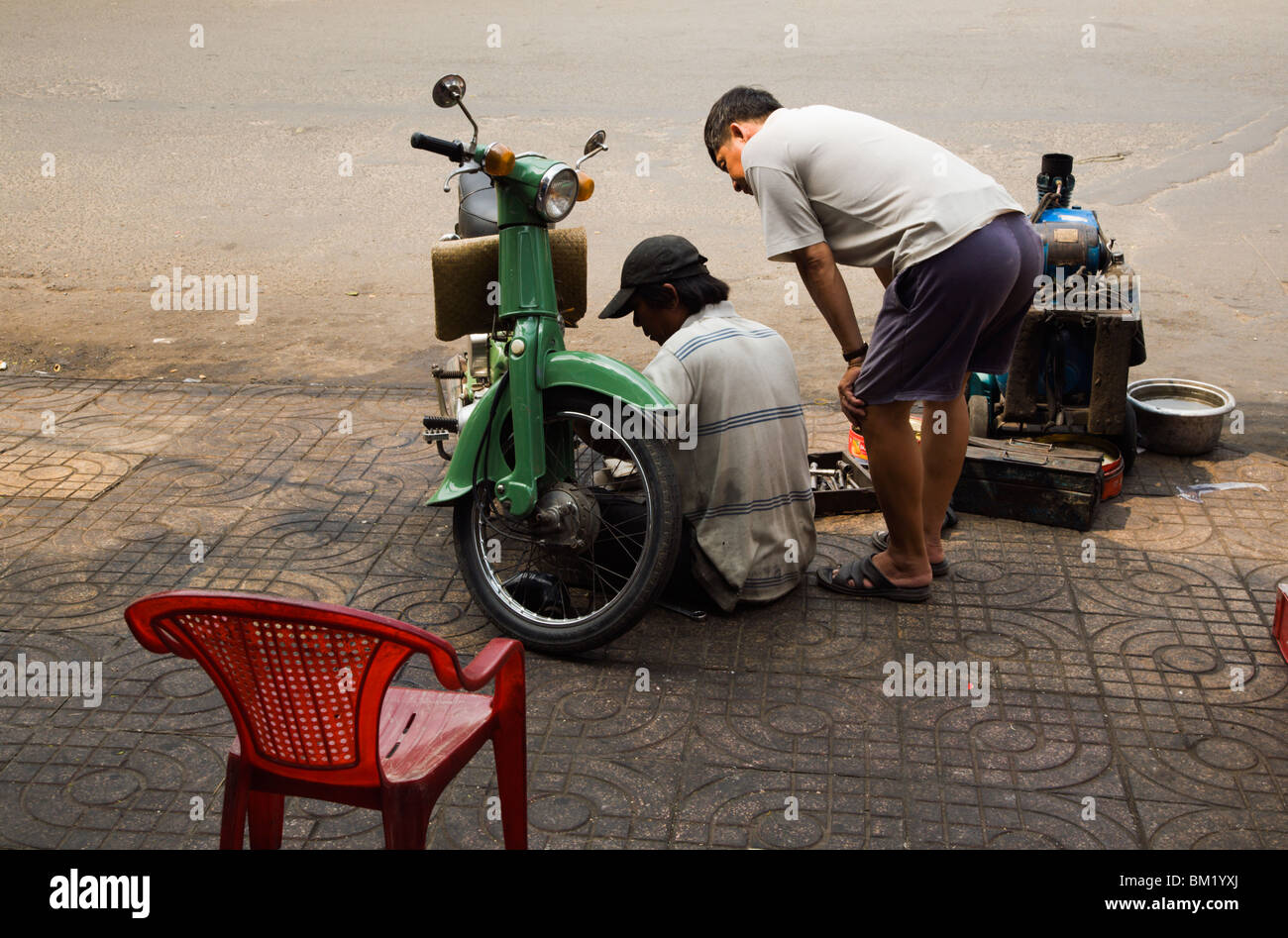 Roadside Motorcycle Mechanic At Work On An Old Honda Cub On