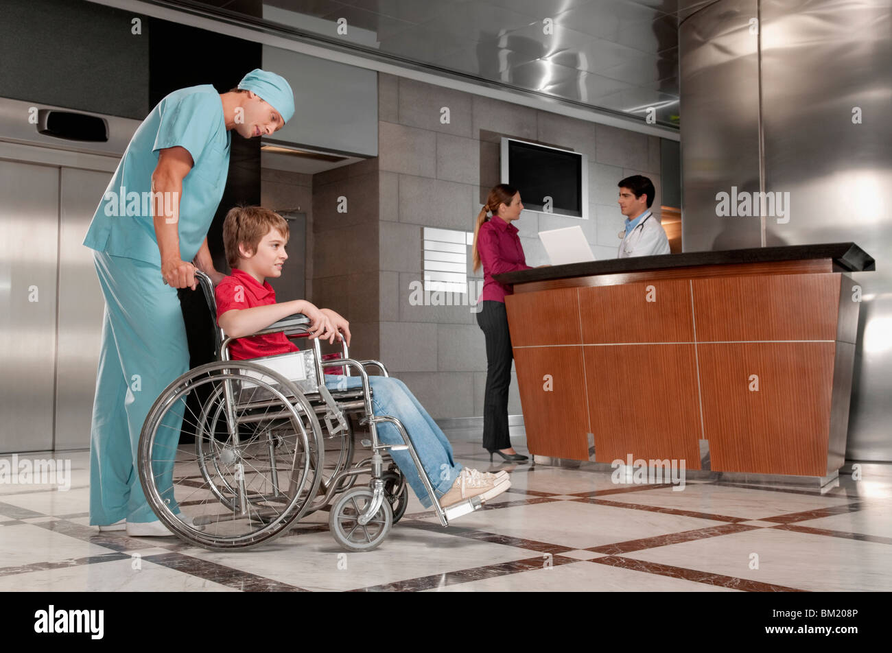 Surgeon pushing a patient in a wheelchair Stock Photo Alamy