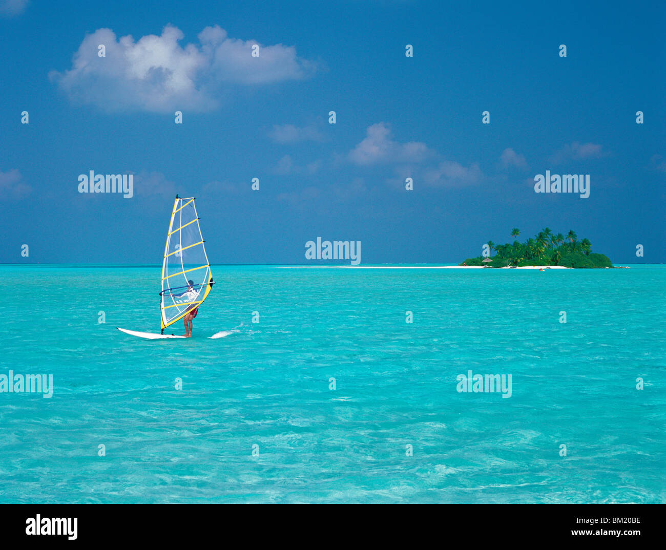 Young man windsurfing near tropical island and lagoon in the Maldives, Indian Ocean Stock Photo