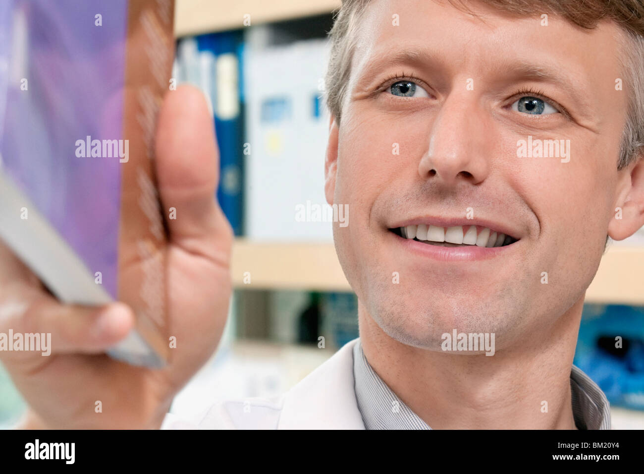 Doctor holding a book and smiling Stock Photo