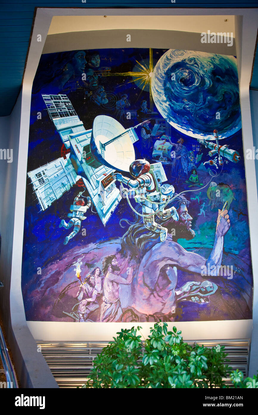 Painted panel shows evolution of man from caveman to space explorer near entrance to Spaceship Earth at Epcot Center Stock Photo