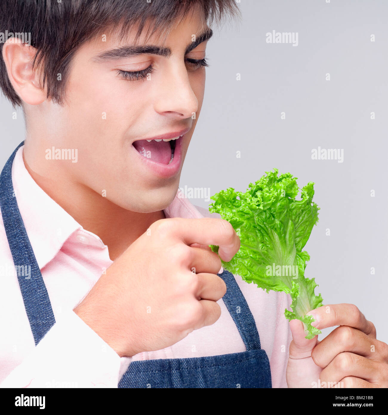 Close-up of a man eating a lettuce leaf Stock Photo