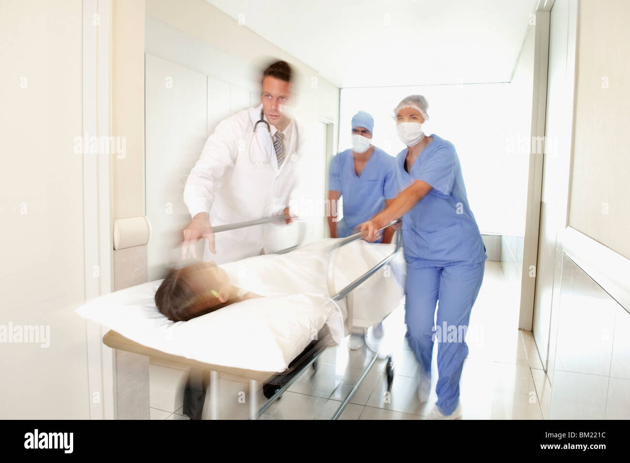 Doctors pushing a patient on a hospital Gurney in a hospital corridor