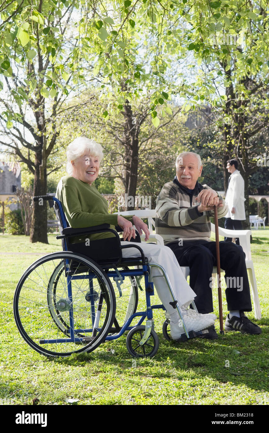Couple sitting in a park Stock Photo - Alamy