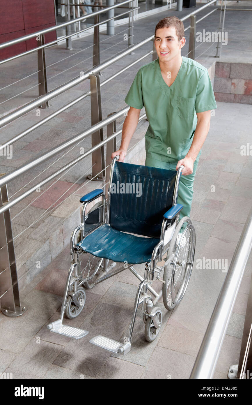 Male nurse carrying a wheelchair Stock Photo