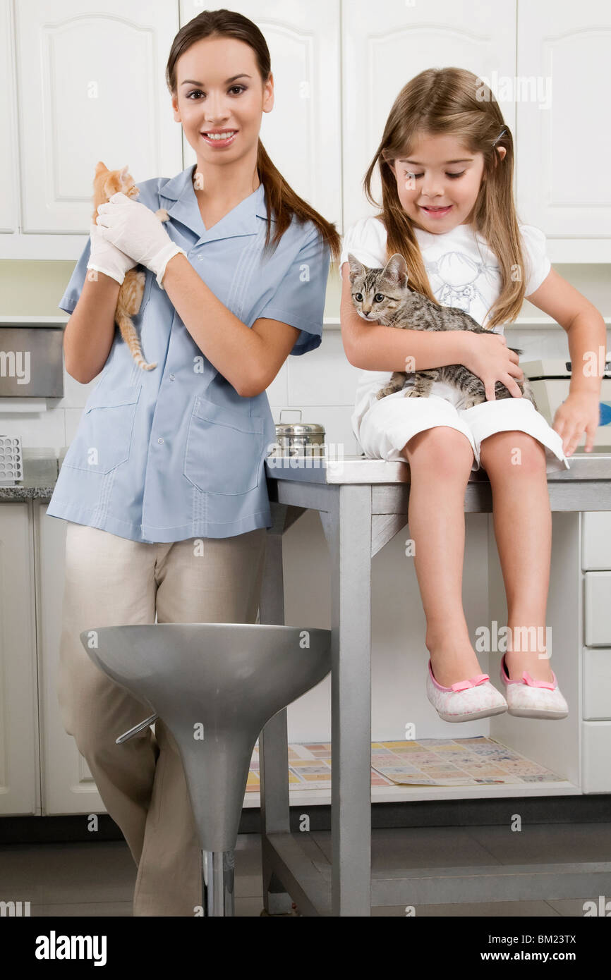 Female vet with a girl carrying cats Stock Photo