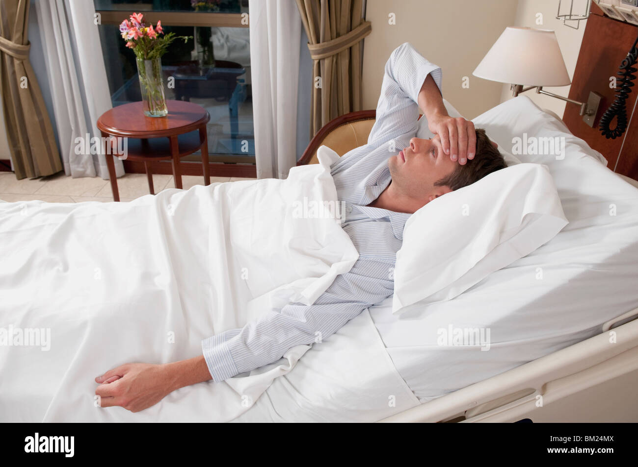 Man lying in a hospital bed Stock Photo - Alamy