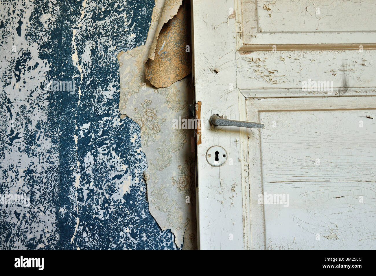 Torn vintage wallpaper peeling paint wall and wooden door in abandoned  house Stock Photo - Alamy