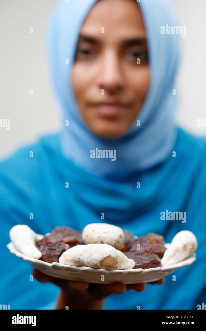 Muslim woman offering Ramadan pastries Stock Photo
