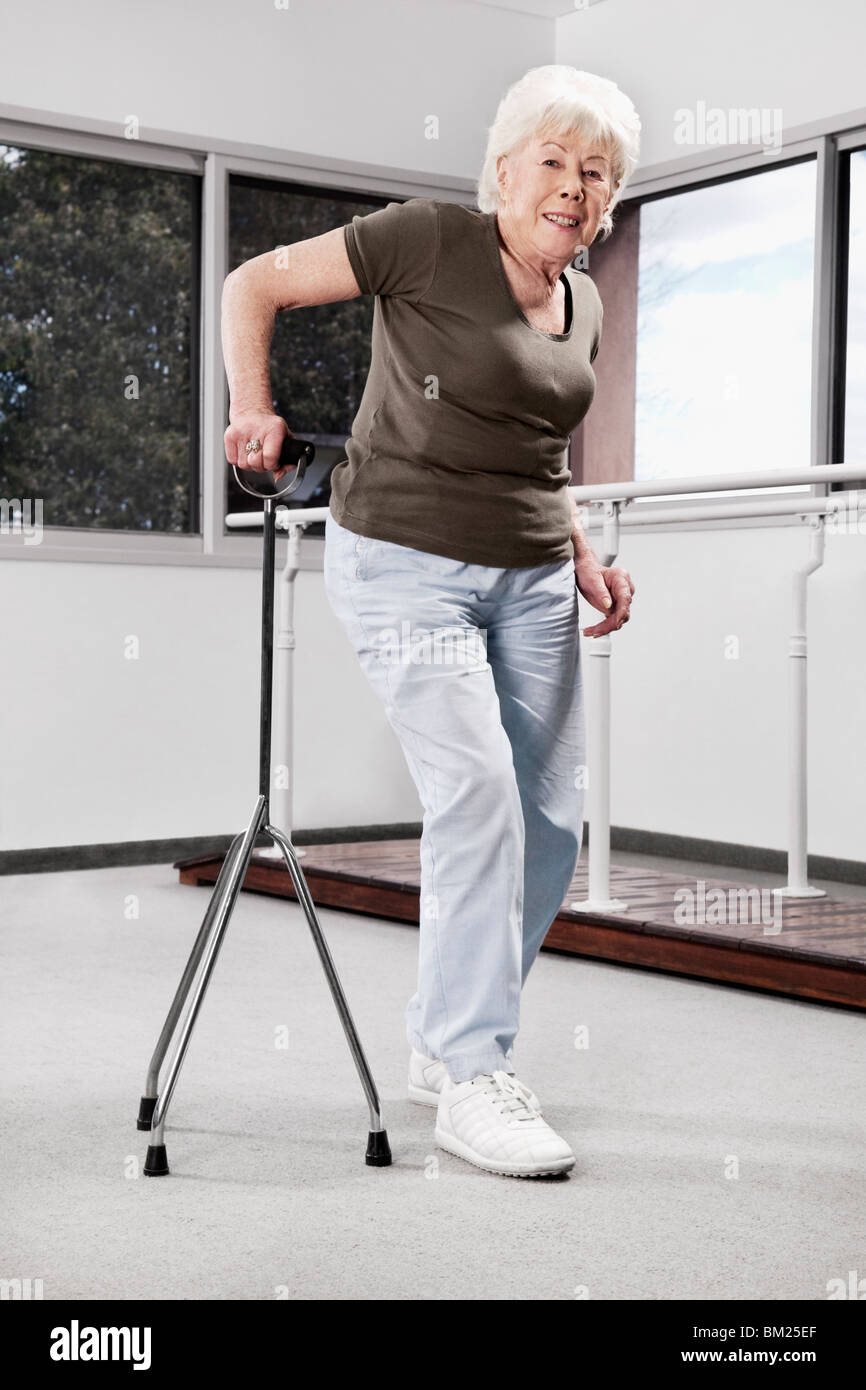 Disabled woman walking with a cane Stock Photo