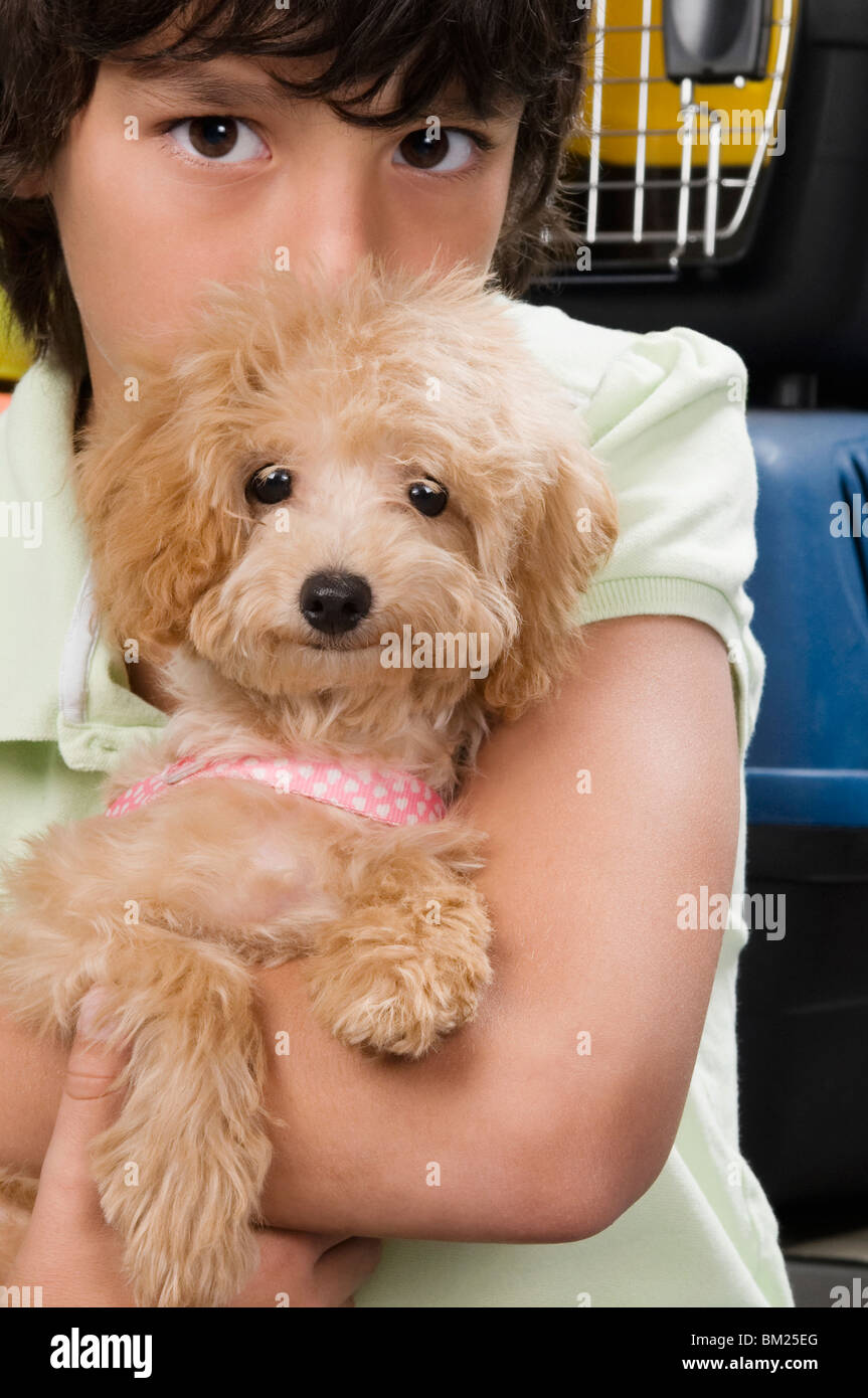 Boy carrying a puppy in a supermarket Stock Photo