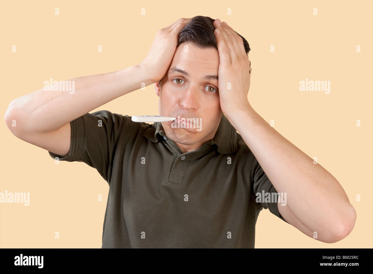 Man checking his temperature with a thermometer Stock Photo Alamy