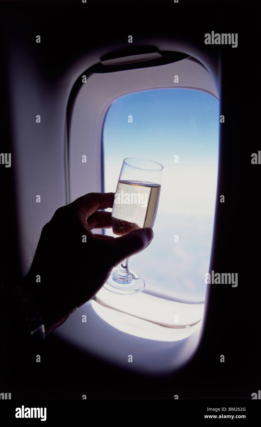 Glass of champagne at 30000 feet and aircraft window Stock Photo