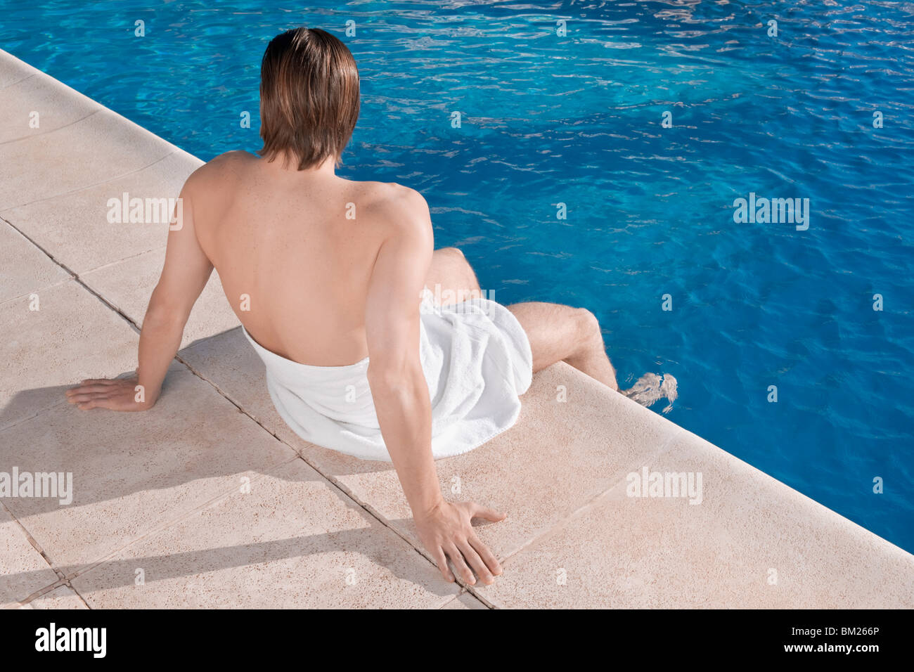 Man resting at the poolside Stock Photo