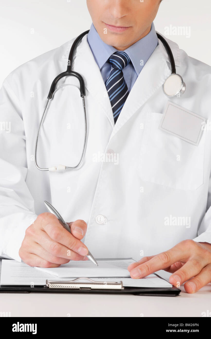 Doctor writing on a clipboard Stock Photo