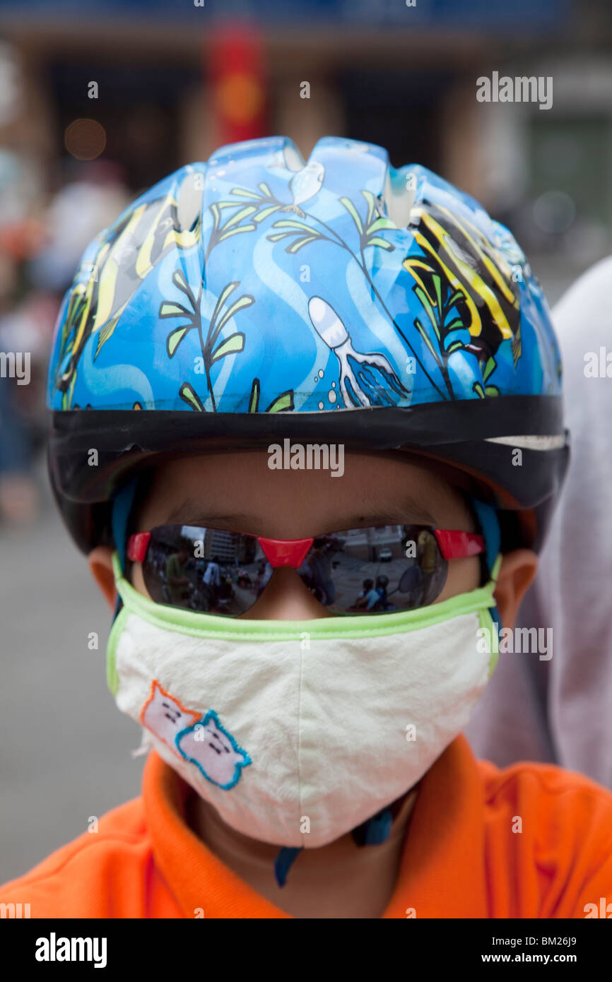Motorcycle passenger wearing pollution mask, Ho Chi Minh City, Vietnam