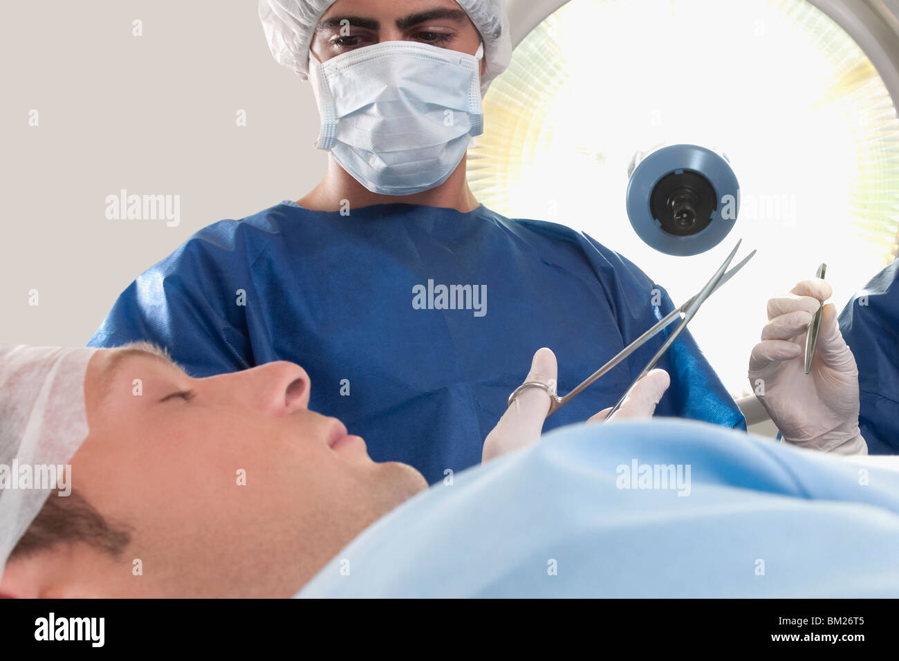 Two surgeons operating a patient in an operating room Stock Photo